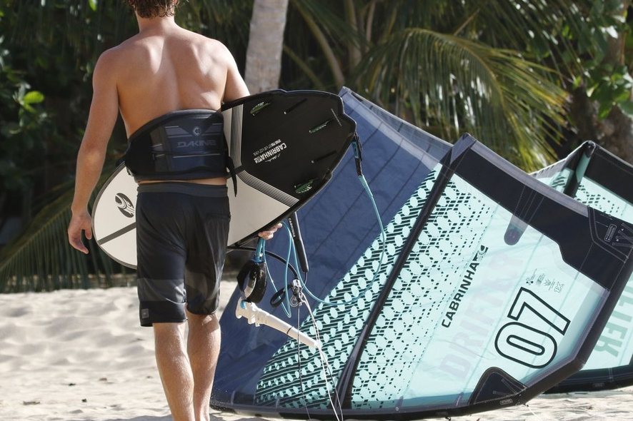 Kiteboarding – jezdec s kitem Cabrinha na pláži